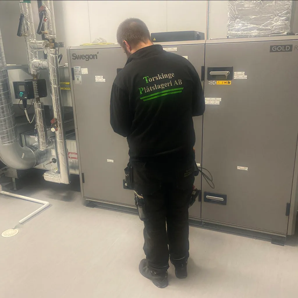 Tekniker arbetar vid ventilationsaggregat